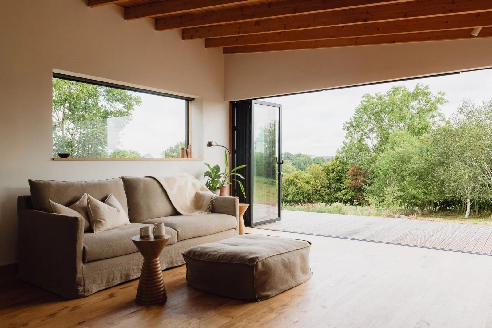 Garden room interior with a sofa and wide glazed doors onto the countryside